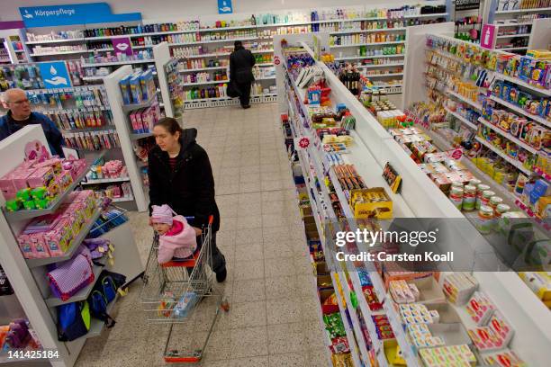 Customer walks past shelves at a Schlecker drugstore on March 16, 2012 in Strausberg, Germany. The German drugstore chain released a list of 2,010...