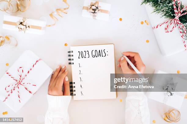 writing new year goals 2023 during holiday celebration. merry christmas and happy new year concept - new years resolution stock pictures, royalty-free photos & images