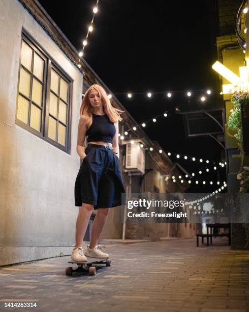 night longboarding l - woman longboard stock-fotos und bilder