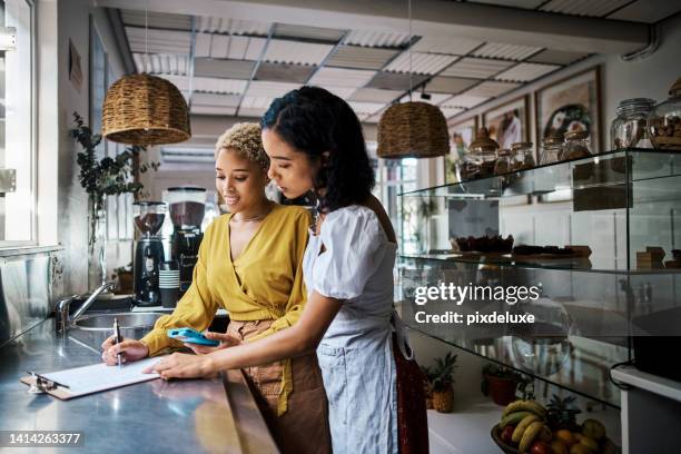 startup entrepreneurs planning menu and preparing a budget for coffee shop, making notes on clipboard in cafe kitchen. small business and restaurant owners doing an audit, checking product inventory. - mini bar stockfoto's en -beelden