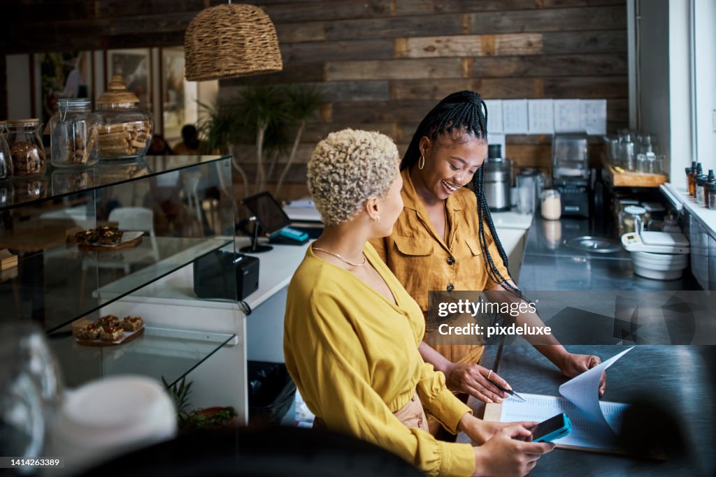 Kleinunternehmer schult neuen Mitarbeiter bei der Arbeit in einem Café. Schwarze Unternehmerinnen in einer Partnerschaft, die zusammenarbeitet und gemeinsam Finanzen und Wachstum im Café plant