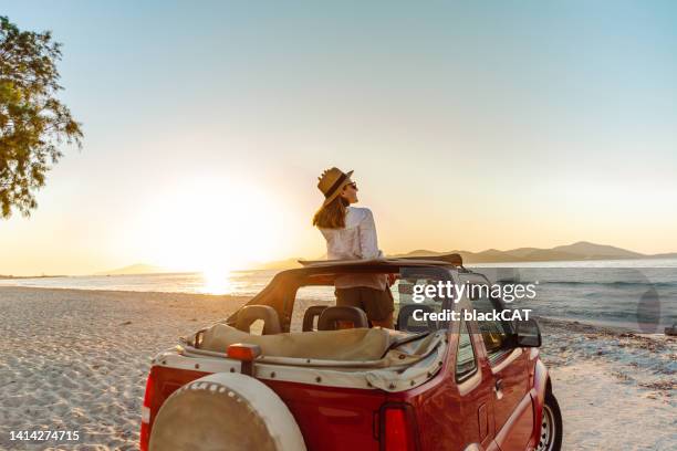 junge frau, die den roadtrip am meer genießt - auto mieten stock-fotos und bilder