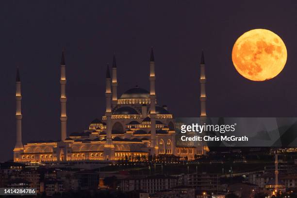 The Sturgeon full moon rises next to Istanbul's Camlica Mosque on August 11, 2022 in Istanbul, Turkey. The Sturgeon Moon is the last super-moon of...