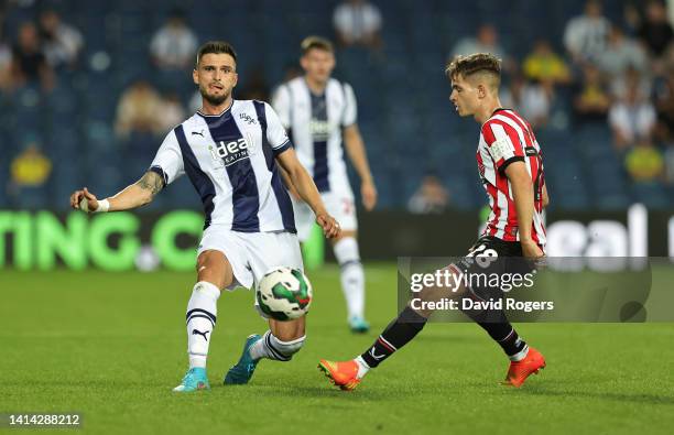 OkayYokuslu of West Bromwich Albion passes the ball pastJames McAtee during the Carabao Cup First Round match between West Bromwich Albion and...