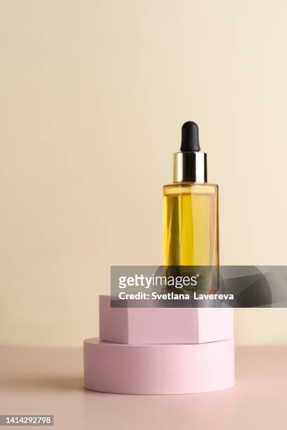 a glass dropper bottle with a pippette with black rubber tip on the white podiums on the light background. nature skin concept. organic spa cosmetics. trendy concept. - cosmetic jar imagens e fotografias de stock