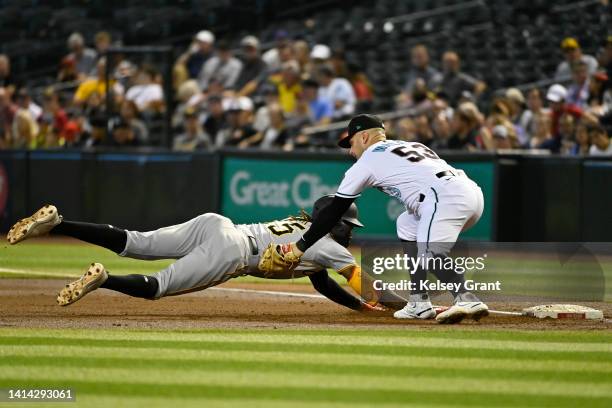 Oneil Cruz of the Pittsburgh Pirates is tagged out by Christian Walker of the Arizona Diamondbacks after getting picked off of first base during the...