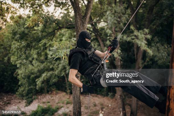 swat team soldier rappelling - military uniform hanging stock pictures, royalty-free photos & images