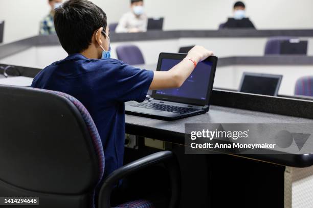 Young Afghan boy looks at a laptop in a computer classroom in the National Conference Center , which in recent months has been redesigned to...