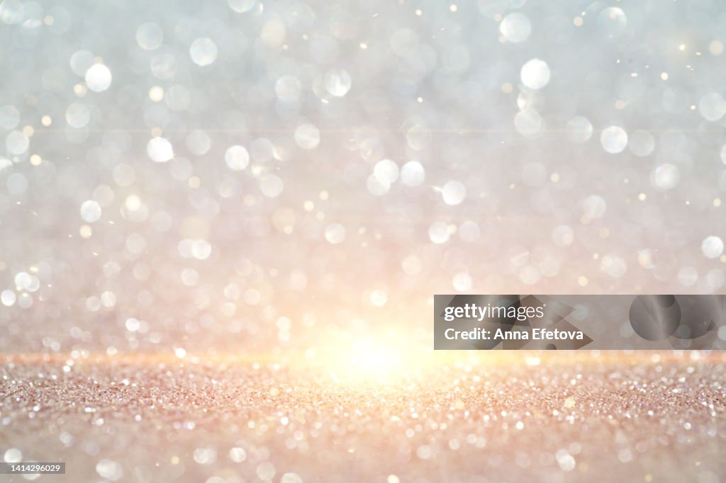 Silver background made of sequins and light beam. Holiday concept. Merry Christmas and a Happy New Year. Copy space for your design. Selective focus