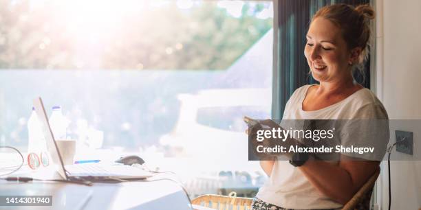 menschen, die im digitalen büro arbeiten, mädchen, die computer für die arbeit und e-learning verwenden. weibliches porträt von frauen in innenräumen, die online mit laptop arbeiten. person mit smartwatch, die das mobiltelefon hält und benutzt. - student girl using laptop computer and smart phone stock-fotos und bilder