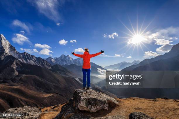 woman lifts her arms in victory, mount everest national park - himalayas climbers stock pictures, royalty-free photos & images