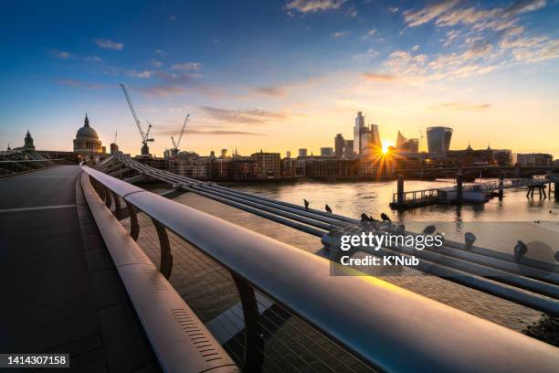 st paul's cathedral and millennium footbridge over the thames river with sunshine over modern skyline at business downtown in london capital city of england, great britain, of united kingdom - k'nub stock pictures, royalty-free photos & images