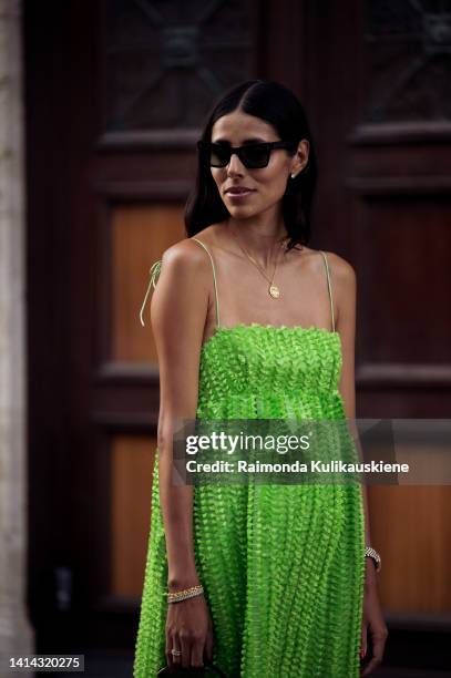 Babba C Rivera wearing green dress, long black boots and black bag posing outside Baum und Pferdgarten during Copenhagen fashion week Spring / Summer...