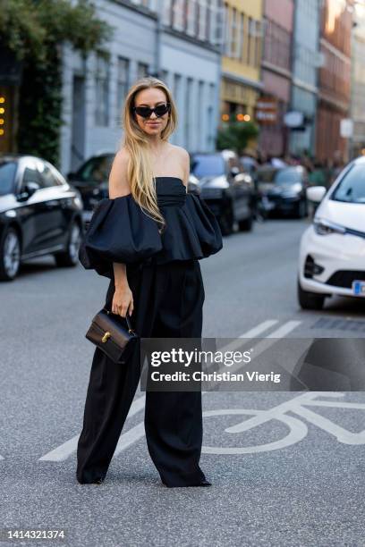 Sandra Hagelstam seen wearing black off shoulder top, pants, bag outside Baum & Pferdgarten during Copenhagen Fashion Week Spring/Summer 2023 on...