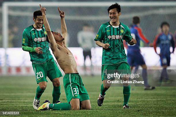 Mao Jinqing celebrates a goal with team mates Zhang Xinxin and Zhou Ting of Beijing Guoan during the Chinese Super League match against Shanghai...