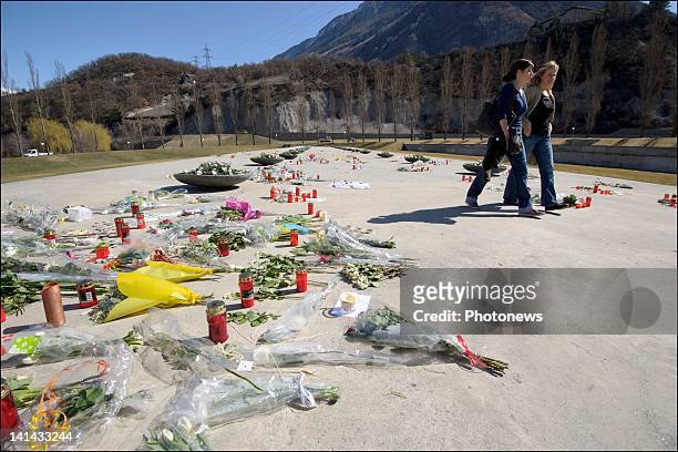 People visit the roof of Sierre's motorway tunnel with flowers and drawings to pay tribute to the victims of the crash on March 16, 2012 in Sierre,...