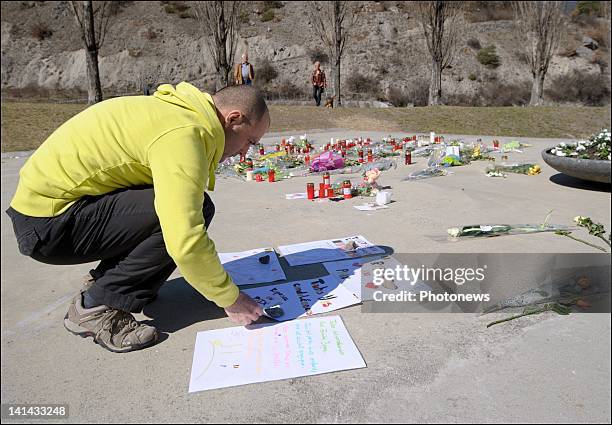 People visit the roof of Sierre's motorway tunnel with flowers and drawings to pay tribute to the victims of the crash on March 16, 2012 in Sierre,...