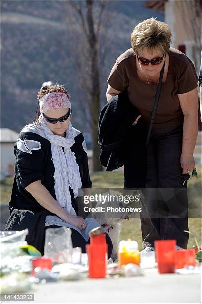 People visit the roof of Sierre's motorway tunnel with flowers and drawings to pay tribute to the victims of the crash on March 16, 2012 in Sierre,...