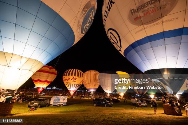 The Night Glow takes place as pilots of hot air balloons light them up in time to music for the crowds at Bristol International Balloon Fiesta at...