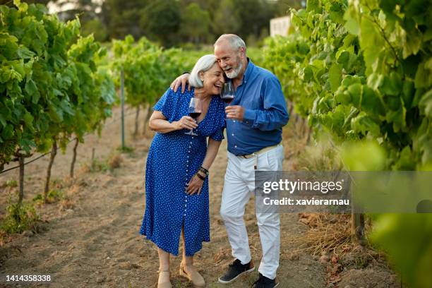 relaxed seniors pausing to laugh as they tour vineyard - prova de vinho imagens e fotografias de stock