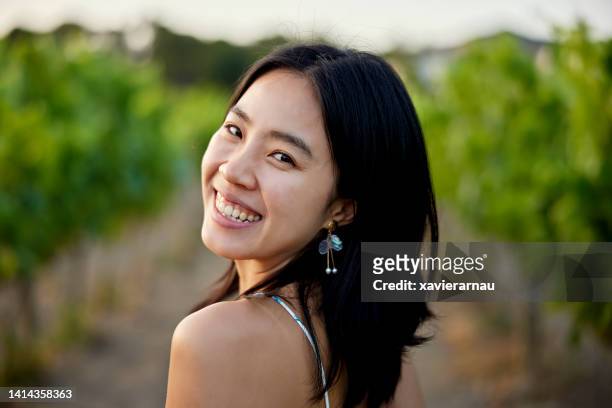 headshot of happy asian woman walking through vineyard - spaghetti strap stock pictures, royalty-free photos & images