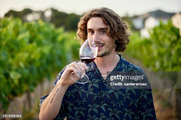 vineyard portrait of young man with glass of red wine - mid length hair stock pictures, royalty-free photos & images