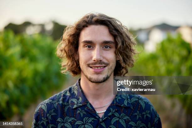 portrait of early 20s man standing in vineyard - wavy hair stock pictures, royalty-free photos & images