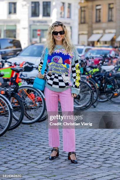 Mija Knezevic is seen wearing pink pants, jumper with print, blue bag outside Saks Potts during Copenhagen Fashion Week Spring/Summer 2023 on August...