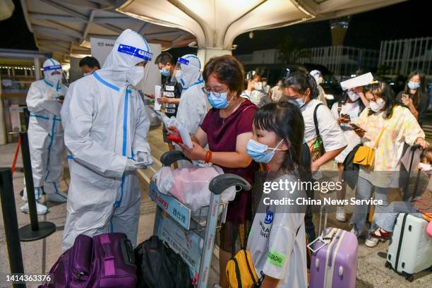 Staff members check tourists' health and nucleic acid testing information at the Haikou Meilan International Airport on August 11, 2022 in Haikou,...