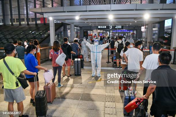 Tourists wait in line to enter the terminal building at the Haikou Meilan International Airport on August 11, 2022 in Haikou, Hainan Province of...