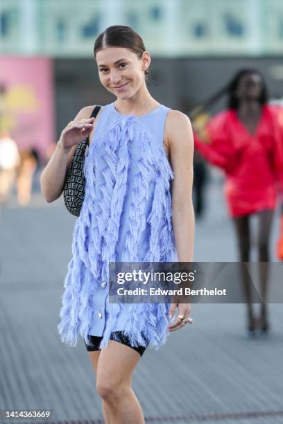 Chloé Ambre Maurin wears a pale purple sleeveless / embroidered fringed / short dress, black cyclist shorts, a black and beige FF monogram print...