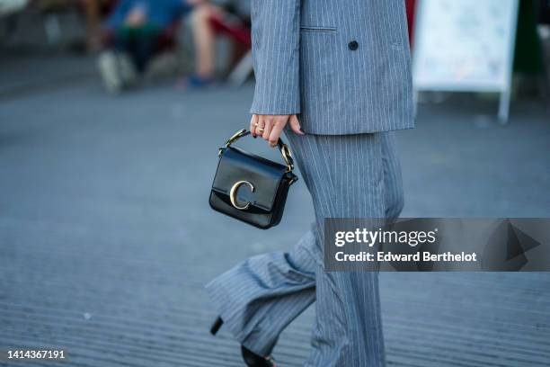 Guest wears a gray and small white striped print pattern blazer jacket, matching gray and small white striped print pattern large suit pants, a black...