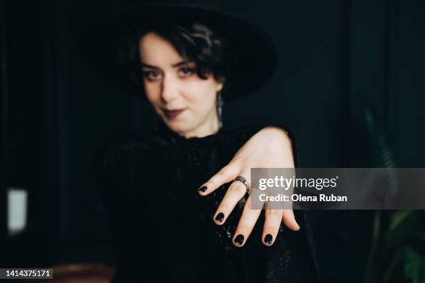 young woman in black dress showing wedding ring. - esmalte de uñas negro fotografías e imágenes de stock