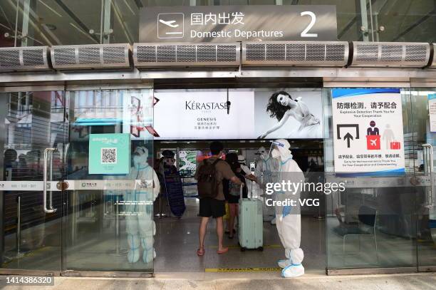 Tourists line up to enter the terminal building at Sanya Phoenix International Airport on August 11, 2022 in Sanya, Hainan Province of China. As of 4...