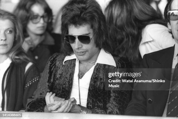 Freddie Mercury of Queen with Mary Austin and manager John Reid at Kempton Park Race Course at a press event for the release of their album 'A Day At...