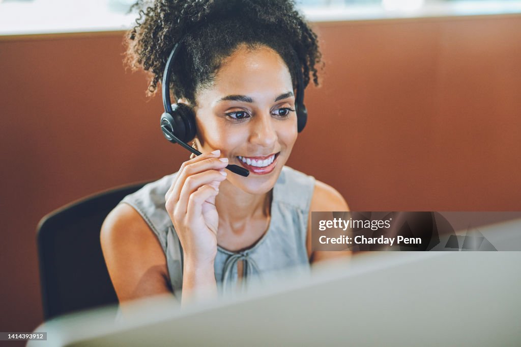 Lächelnde, helfende und arbeitende Kundendienstmitarbeiter mit einem Headset und einem Bürocomputer. Call-Center-Mitarbeiter bei einem Online-Internet-Beratungsanruf. Telefonist, der Web-Beratung gibt