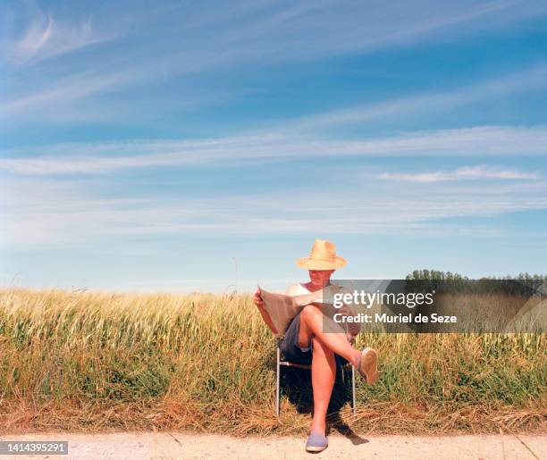 man reading newspaper by cornfield - langzaam stockfoto's en -beelden