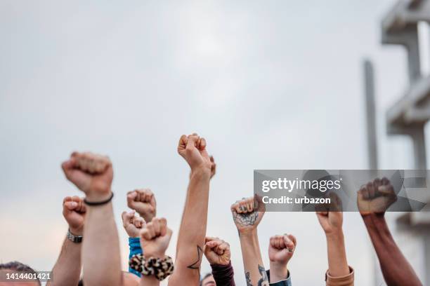 protestors raising fists - street demonstration stock pictures, royalty-free photos & images
