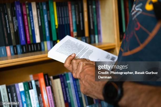 a man flipping through a book at a bookstall - book shop stock pictures, royalty-free photos & images