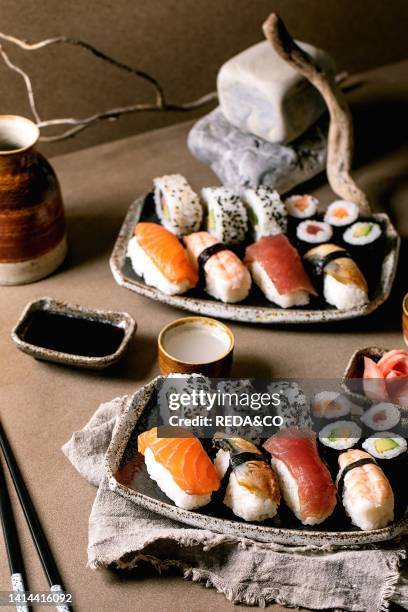 Sushi rolls set for two. Traditional japanese dish sushi and rolls with fresh salmon, tuna, eel and prawns on rice. Serving on plates with soy sauce...