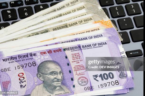 indian currency notes on laptop keyboard - gandhi stock-fotos und bilder