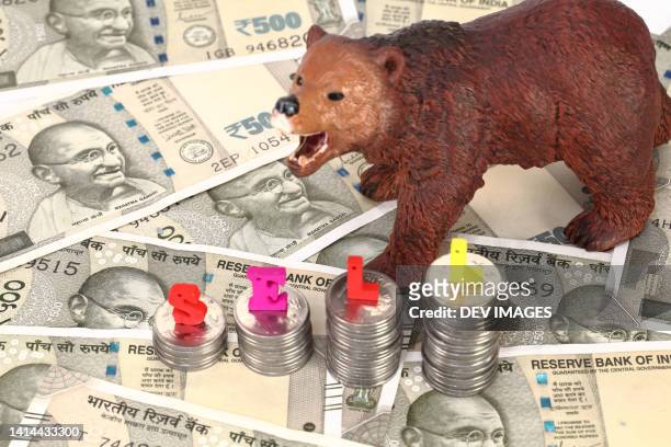 bear figurine on indian currency notes - volatility stock pictures, royalty-free photos & images