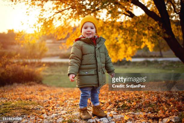 caucasian toddler boy enjoy the autumn day in the nature - baby boot stock pictures, royalty-free photos & images