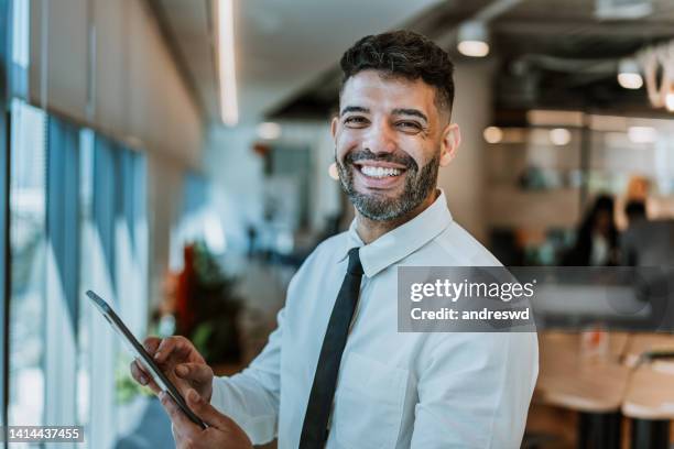 portrait of a businessman holding digital tablet - business man laughing stock pictures, royalty-free photos & images