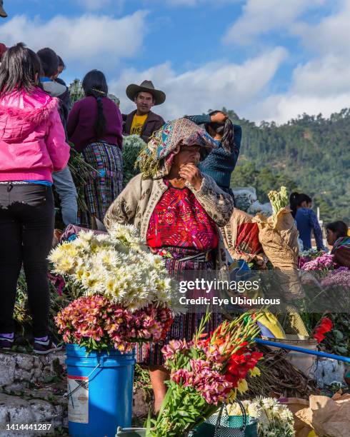 Guatemala, El Quiche Department, Chichicastenango, Quiche Mayan woman in traditional dress selling flowers on the steps of the Church of Santo Tomas.