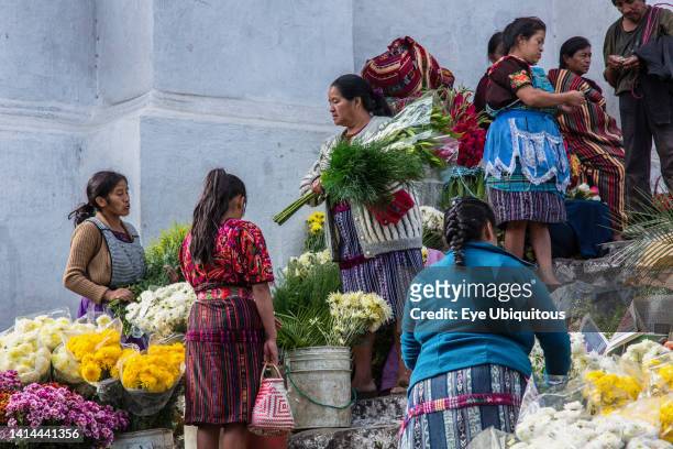 Guatemala, El Quiche Department, Chichicastenango, Quiche Mayan women in traditional dress selling flowers on the steps of the Church of Santo Tomas.