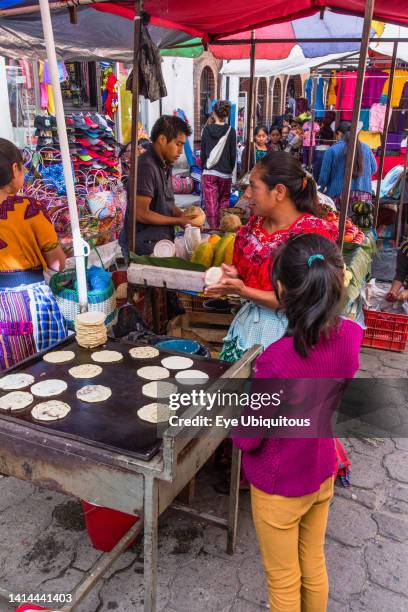 Guatemala, El Quiche Department, Chichicastenango, A Quiche Mayan woman makes tortillas in a food stall at the Indian market.