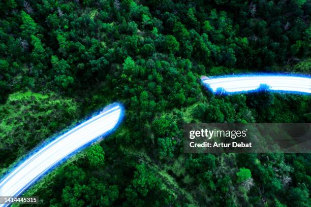 blue light trails flowing fast in a highway with tunnel and nature, with sustainable and zero emissions transport. - sustainable transportation stock pictures, royalty-free photos & images