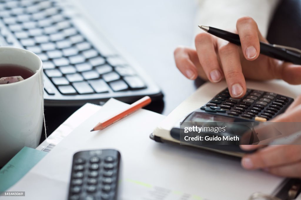 Woman hand using calculator