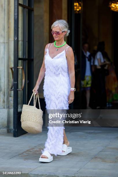 Guest is seen wearing white dress outside Helmstedt during Copenhagen Fashion Week Spring/Summer 2023 on August 11, 2022 in Copenhagen, Denmark.